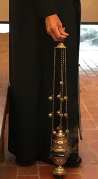 Deacon stands with smoking censer