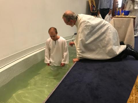 A candidate for baptism entering the baptismal font