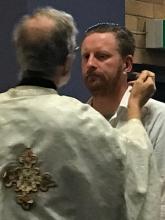Priest applying the Holy Chrism to a baptismal candidate