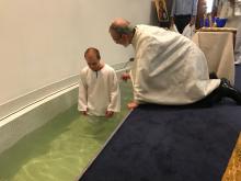 A candidate for baptism entering the baptismal font